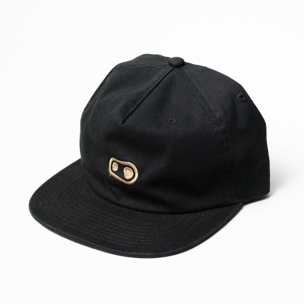 Black cap with a gold Crankbrothers logo on a white background