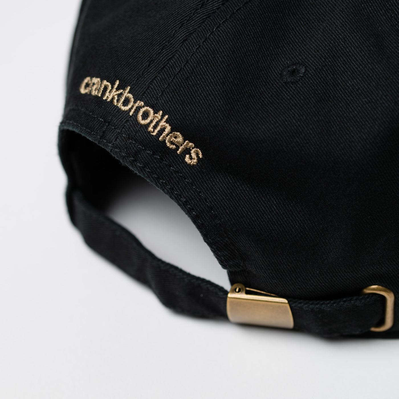 Black cap with ' crankbrothers' logo on a light gray background